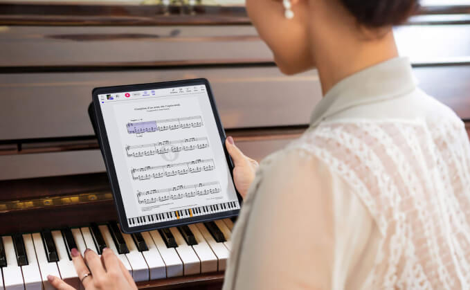 Vrouw speelt piano in haar woonkamer